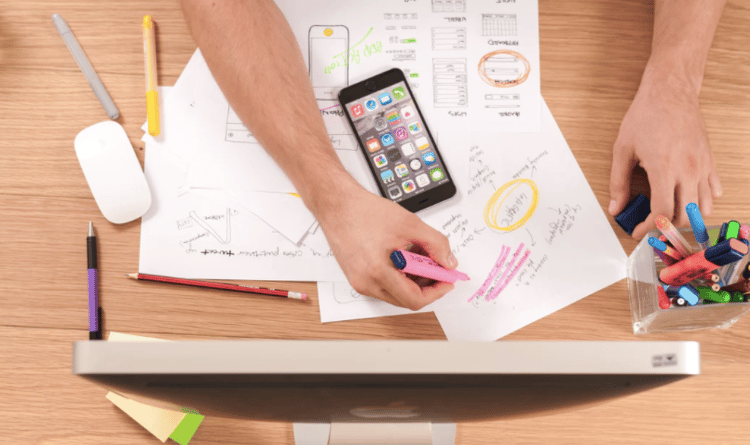 Person with smart phone is sketching with a pink marker.